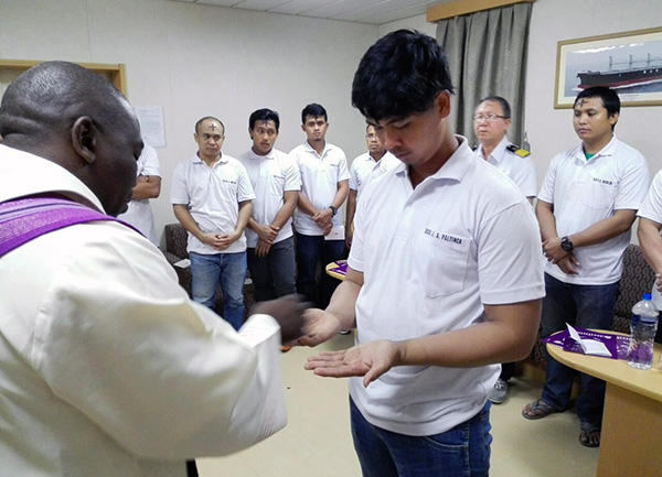Fr Bongani distributes ash to seafarers on board African Bateleur
