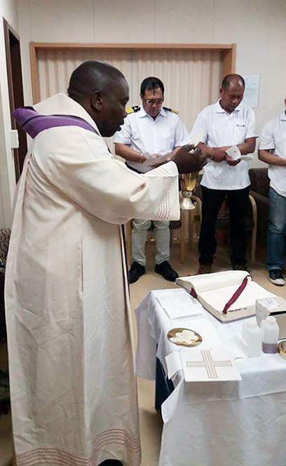 Fr Bongani distributes ash to seafarers on board African Bateleur